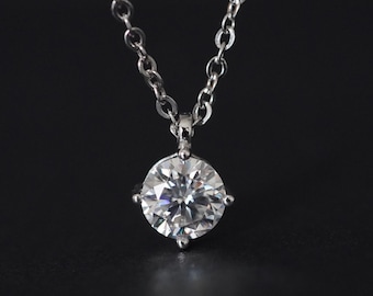 May include: A silver chain necklace with a large, clear, round diamond pendant.