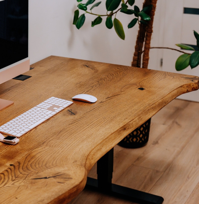 K&ouml;nnte beinhalten: Ein Holzschreibtisch mit einer wei&szlig;en Tastatur und einer wei&szlig;en Maus. Der Schreibtisch hat eine nat&uuml;rliche Holzoptik und ein Live-Edge-Design. Der Schreibtisch steht auf einem hellen Holzboden.