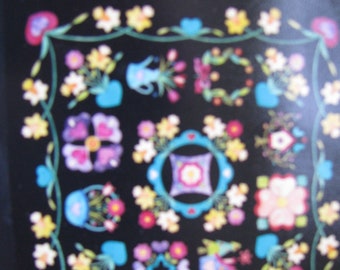 Könnte beinhalten: Ein schwarzes quadratisches Design mit farbenfrohen Blumenmustern. Das Design umfasst verschiedene Blumenarrangements in Vasen, Kränzen und einzelnen Blüten, umrahmt von einem Rand aus Blumen und Ranken. Die Farbpalette umfasst Rosa, Gelb, Blau und Lila.