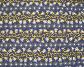 Könnte beinhalten: Ein dunkelblauer Stoff mit einem sich wiederholenden Muster aus horizontalen Reihen. Das Design besteht aus abwechselnden Bändern aus gelben, rankenartigen Stielen mit kleinen weißen Blütenclustern und Reihen kleiner, weiß-gelber Sternpunkte.