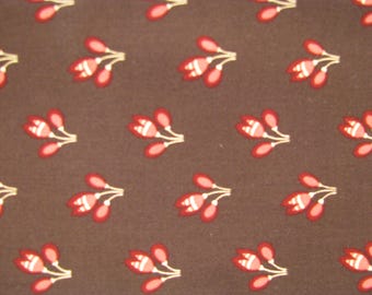 Peut inclure: Un tissu marron présentant un motif répétitif de petites fleurs. Chaque motif se compose de trois boutons de fleurs stylisés rouges et blancs reliés par de fines tiges blanches, disposés en une grille régulière sur toute la surface du tissu.