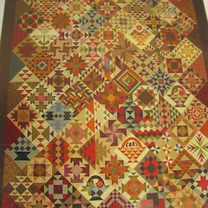 May include: A quilt block sampler featuring a grid of various square fabric patches in shades of brown, red, orange, and cream. The design includes geometric patterns, star motifs, and basket illustrations with the text "Quilt Block Sampler" at the top.