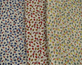 Peut inclure: Trois échantillons de tissu avec un fond blanc et un motif répétitif de petites feuilles et baies rouges, bleues ou jaunes.