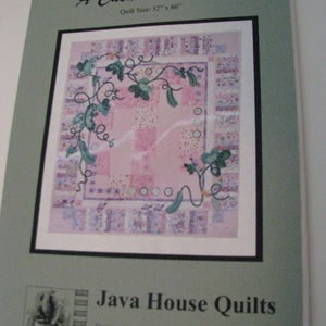 May include: A quilt pattern titled "A Cucumber Number" with a pink and purple design. The quilt size is 52" x 60". The design features a floral vine with cucumbers. The Java House Quilts logo is at the bottom.