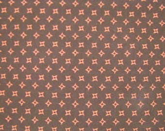 Peut inclure: Un tissu marron foncé présentant un motif répétitif de petites étoiles orange clair à quatre branches disposées en grille. Les étoiles ont des côtés incurvés et sont régulièrement espacées sur toute la surface du textile.
