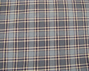 Könnte beinhalten: Ein Stoff mit einem Karomuster in Schieferblau, Marineblau und Cremetönen. Das Design besteht aus sich kreuzenden horizontalen und vertikalen Linien unterschiedlicher Dicke, die ein sich wiederholendes Gitter aus Quadraten auf der gesamten Fläche bilden.