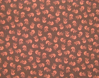 Peut inclure: Un tissu marron foncé présentant un motif répétitif de petites fleurs orange clair. Chaque motif se compose d'une minuscule tête de fleur avec une tige et deux petites feuilles, réparties uniformément sur toute la surface du textile.