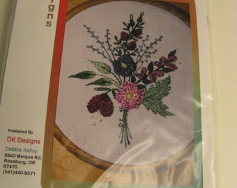 Könnte beinhalten: Ein Simply Irresistible Stickset für brasilianische Reliefstickerei für Anfänger von DK Designs, Nummer 3829. Die Packung zeigt ein Blumenmotiv auf Stoff in einem Holzrahmen mit einer aufgedruckten Motivgröße von 8,89 cm mal 11,43 cm.