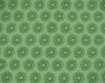 Peut inclure: Un tissu vert clair présentant un motif répétitif de fleurs circulaires vert foncé. Le fond est rempli d'une disposition dense de petits points vert foncé, créant un aspect texturé sur toute la surface du textile.