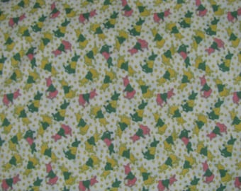 Peut inclure: Un tissu blanc avec un motif répétitif de petits personnages de dessin animé en rose, jaune et vert, parsemé de minuscules points jaunes. Le design couvre toute la surface avec une disposition dense de ces figures colorées.