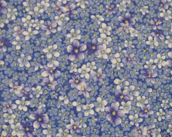 Könnte beinhalten: Ein Stoffmuster mit einer dichten Anordnung kleiner fünfblättriger Blüten in Violett-, Hellblau- und Weißtönen. Das florale Design ist auf einem mittelblauen Hintergrund platziert, wobei jede Blüte eine kleine gelbe Mitte hat.