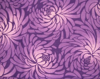 Könnte beinhalten: Ein Stoff mit einem sich wiederholenden Muster aus großen, stilisierten Chrysanthemenblüten in tiefen Violett- und hellen Lavendeltönen. Das Design besteht aus geschichteten, geschwungenen Blütenblättern, die von einem Zentrum ausgehen.