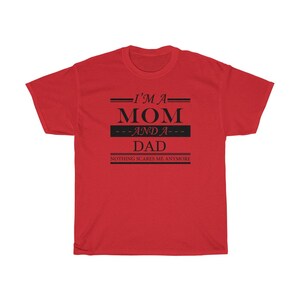 May include: Red t-shirt with black text that reads "I'm a Mom and a Dad. Nothing scares me anymore."