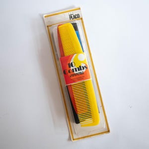 May include: A package of 10 yellow combs with a red and yellow label that says "10 Combs Unbreakable". The package is on a white background.