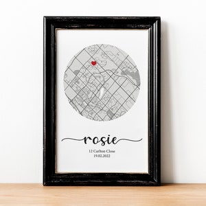 May include: A black framed print with a gray and white map of a city with a red heart marking a location. The text "rosie" is written in cursive below the map, followed by "12 Carlton Close 19.02.2022".