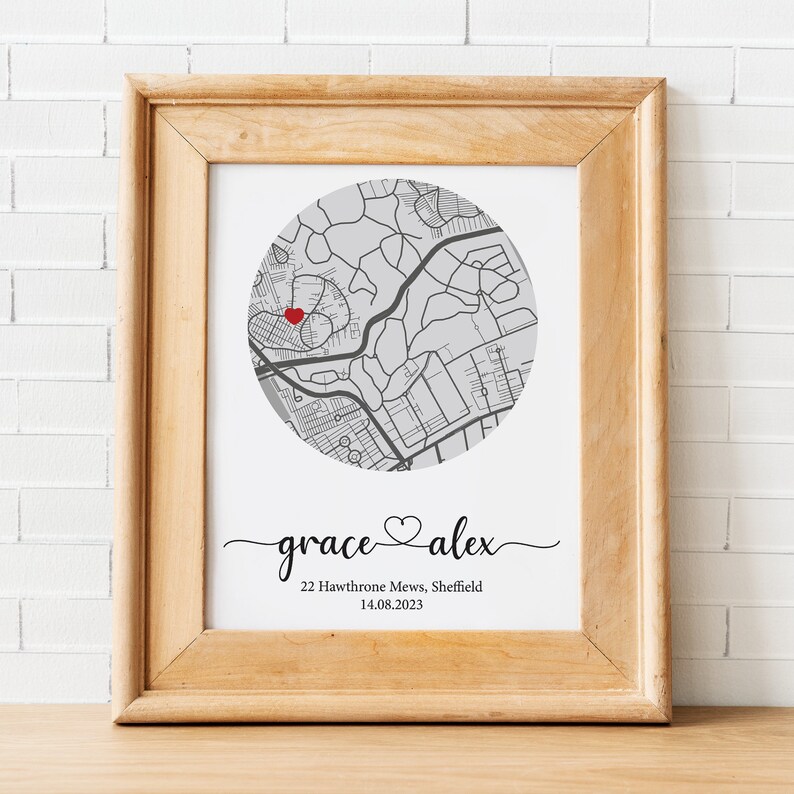 May include: A framed print with a map of a city in a circle. A red heart is placed on the map. The text below the map reads "grace &hearts; alex", "22 Hawthorne Mews, Sheffield", and "14.08.2023".