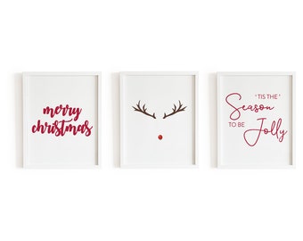 May include: Three white framed prints with red and brown text and illustrations. The first print says "merry christmas". The second print has a brown reindeer silhouette with a red nose. The third print says "'Tis the season to be jolly".