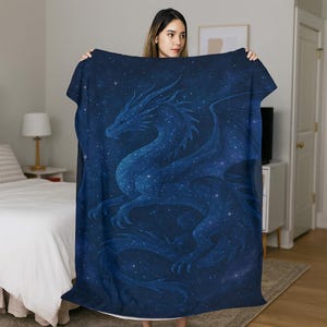 Puede incluir: Una manta azul oscuro con un diseño de dragón celestial. El dragón está detallado sobre un cielo estrellado. Esta suave manta es un elemento de decoración del hogar acogedor.