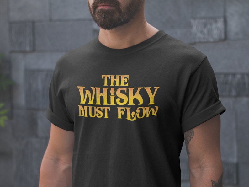 May include: Black t-shirt with a yellow and orange graphic that says "The Whisky Must Flow".
