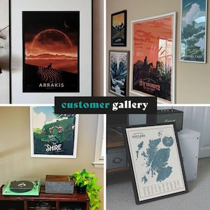May include: A collection of framed art prints, including a landscape with the word "Arrakis", a map of Scotland, and other scenic designs. The prints are displayed in a customer gallery setting, showcasing various sizes and styles.