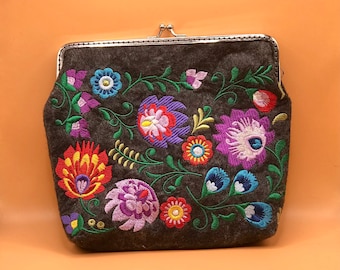 The wallet is large embroidered in a floral style.