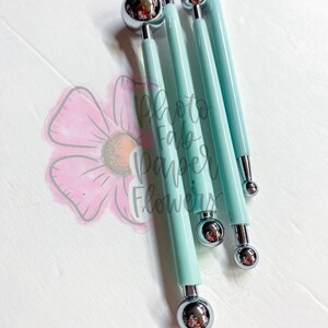 May include: Set of four blue handled tools with round metal tips of varying sizes. The tools are used for creating paper flowers.