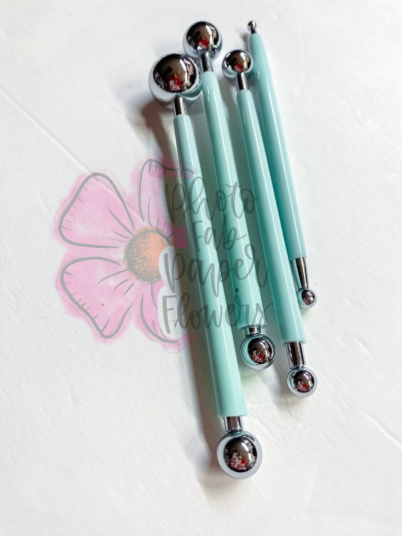 May include: Set of four blue handled tools with round metal tips of varying sizes. The tools are used for creating paper flowers.