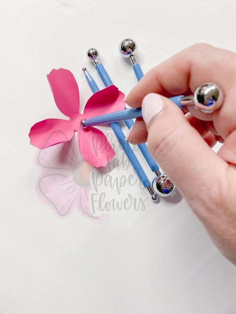 May include: A set of four blue handled tools with round metal tips. The tools are used to create texture and detail in paper flowers. The tools are being used to create a pink paper flower.