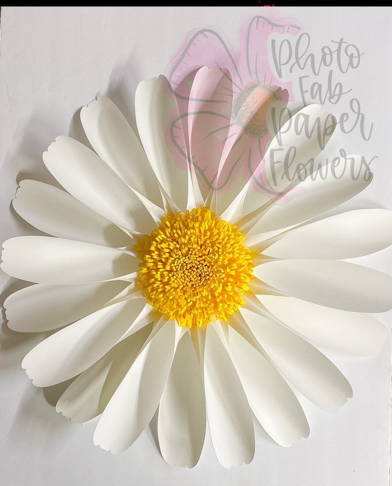 May include: A large white paper daisy with a yellow center. The daisy is made of multiple layers of paper petals.