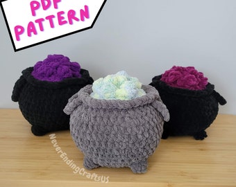 May include: Three crocheted cauldron pillows, one gray, one black, and one purple. Each cauldron has a different colored filling, green, purple, and pink. The pillows are on a wooden surface. The text "PDF PATTERN" is in a pink box in the upper left corner of the image.
