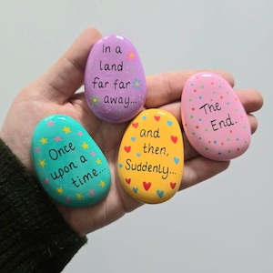 May include: Four painted stones with different phrases: "Once upon a time...", "In a land far far away...", "and then, Suddenly...", and "The End."