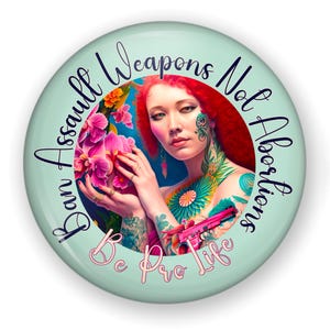May include: Round, light green button with the text "Ban Assault Weapons Not Abortions" and "Be Pro Life". The button features a woman with red hair, tattoos, and holding a pink handgun, surrounded by flowers.