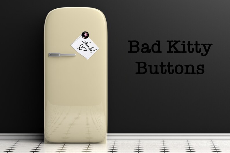 May include: A vintage-style, cream-colored refrigerator with a note that says "Thanks!" on it. The refrigerator is in front of a black wall with the text "Bad Kitty Buttons" written on it.