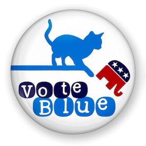 May include: A white button with a blue cat stepping on a red, white, and blue elephant. The text "Vote Blue" is written in blue letters on the button.