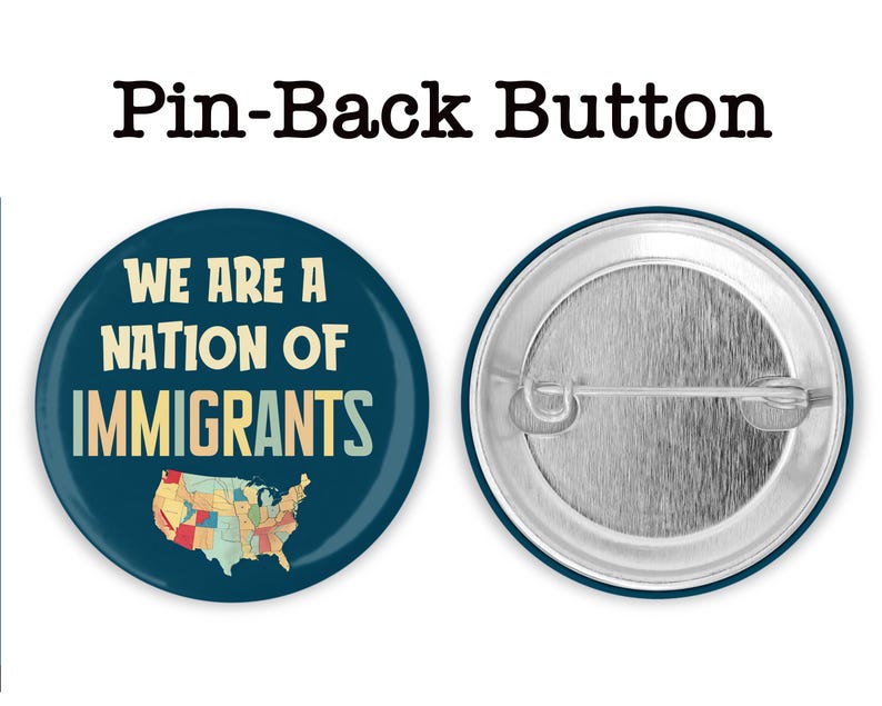 K&ouml;nnte beinhalten: Ein runder Ansteckbutton mit dem Text "WE ARE A NATION OF IMMIGRANTS" in wei&szlig;er und beiger Schrift und einer Karte der Vereinigten Staaten. Der Button ist dunkelblau und hat eine silberne Metallr&uuml;ckseite.