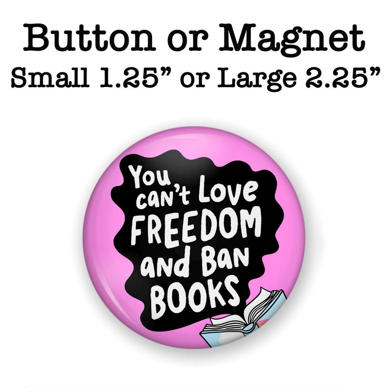 Puede incluir: Un bot&oacute;n o im&aacute;n redondo con el texto "You can't love freedom and ban books" en blanco sobre una forma negra, sobre un fondo rosa. El bot&oacute;n est&aacute; disponible en tama&ntilde;os de 3,18 cm o 5,72 cm. Ilustraci&oacute;n de un libro abierto en la parte inferior.
