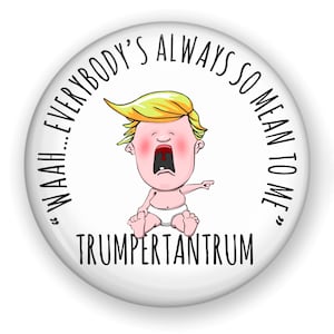 May include: A white button with a cartoon image of a baby with blonde hair crying and pointing. The text around the image reads "WAAAH...EVERYBODY'S ALWAYS SO MEAN TO ME" and "TRUMPERTANTRUM".
