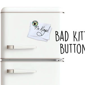 May include: A white refrigerator with silver handles and the text "BAD KITTY BUTTONS" in black. A small button and a notepad with the words "No Kings!" are attached to the refrigerator.