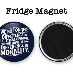 May include: A navy blue fridge magnet with white text that reads "WE NO LONGER HAVE A DIFFERENCE IN POLITICAL OPINION. WE HAVE A DIFFERENCE IN MORALITY." The magnet is round with a silver rim. The words "Fridge Magnet" are at the top.
