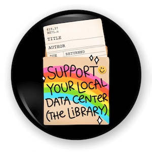 May include: A circular pin featuring a tan library card pocket with a rainbow graphic and the text SUPPORT YOUR LOCAL DATA CENTER (THE LIBRARY). A library checkout card is tucked inside the pocket, displaying the call number 619.37 RS71.n.