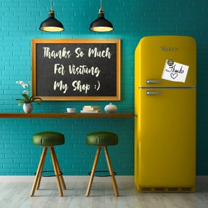 K&ouml;nnte beinhalten: Ein gelber Retro-K&uuml;hlschrank mit einem handgeschriebenen Zettel mit der Aufschrift "Danke" an der T&uuml;r. An einer tealfarbenen Backsteinwand h&auml;ngt ein Schild aus Schiefer mit der Aufschrift "Vielen Dank f&uuml;r Ihren Besuch in meinem Shop :)". Vor einer Holztheke stehen zwei Holzbarhocker mit gr&uuml;nen Sitzen.