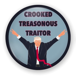 May include: A round button with a blue background and a black border. The button features a cartoon image of a man with a red tie and a white shirt, making a peace sign with both hands. The text "CROOKED TREASONOUS TRAITOR" is printed in black letters on the button.