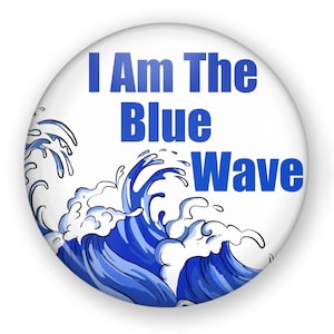 May include: A white button with a blue wave design and the text "I Am The Blue Wave".