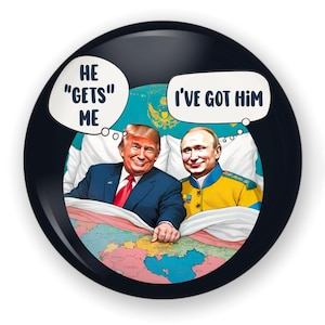 May include: A black and white button with a cartoon image of Donald Trump and Vladimir Putin in bed together. Trump is saying "He "gets" me" and Putin is saying "I've got him".