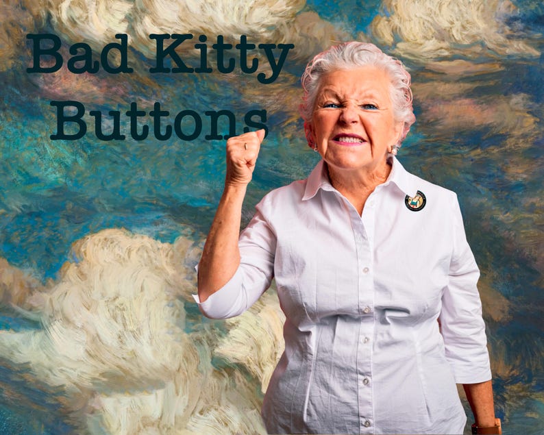 Może przedstawiać: Starsza osoba w białej koszuli z przypinką. Obrazek zawiera tekst "Bad Kitty Buttons" w ciemnozielonym kolorze. Tło to obraz z kolorami niebieskim, białym i brązowym.