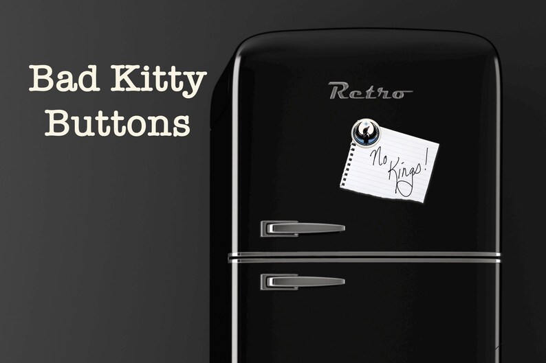May include: A black retro refrigerator with silver handles and trim. A magnet holds a note that reads "No Kings!". The words "Bad Kitty Buttons" are in white text on the left side of the image.