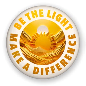May include: A white button with a yellow sun rising over a landscape. The text "BE THE LIGHT MAKE A DIFFERENCE" is written around the sun in a circle.