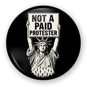 May include: A black button featuring a graphic of the Statue of Liberty holding a sign that reads "NOT A PAID PROTESTER" in white text. The image has a vintage, distressed look.