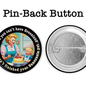 Op de afbeelding: Een pin-back button met een retro illustratie van een vrouw en kind die een taart versieren. De button heeft de tekst "No you can't have Greenland yet, you haven't finished your Venezuela". De achterkant van de button is zilver.