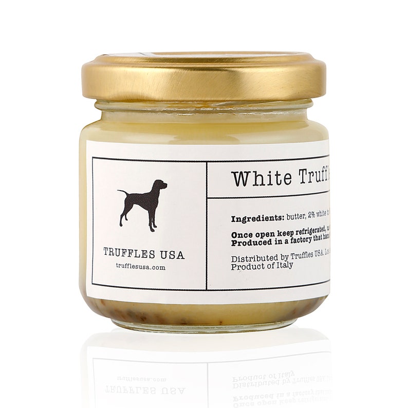 May include: A small glass jar of White Truffle product with a gold lid. The label features a black silhouette of a dog and the text "TRUFFLES USA". The ingredients and origin are also listed on the label.